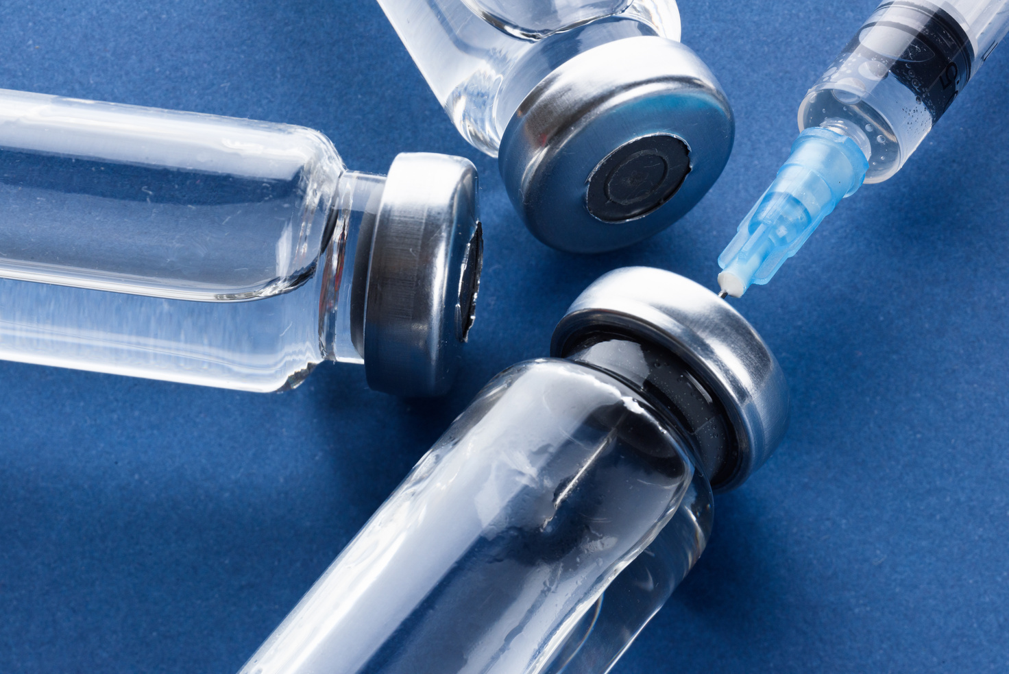 Medical ampoule for injection on blue. Medicine for vaccination.